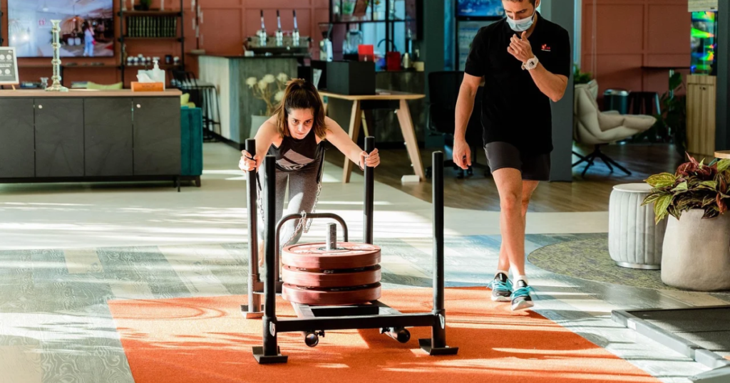medical fitness trainer assessing client movement
